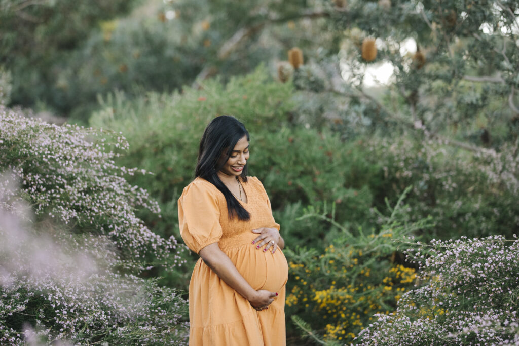 natural maternity photo of mum looking down at her baby bump Perth in Kings Park