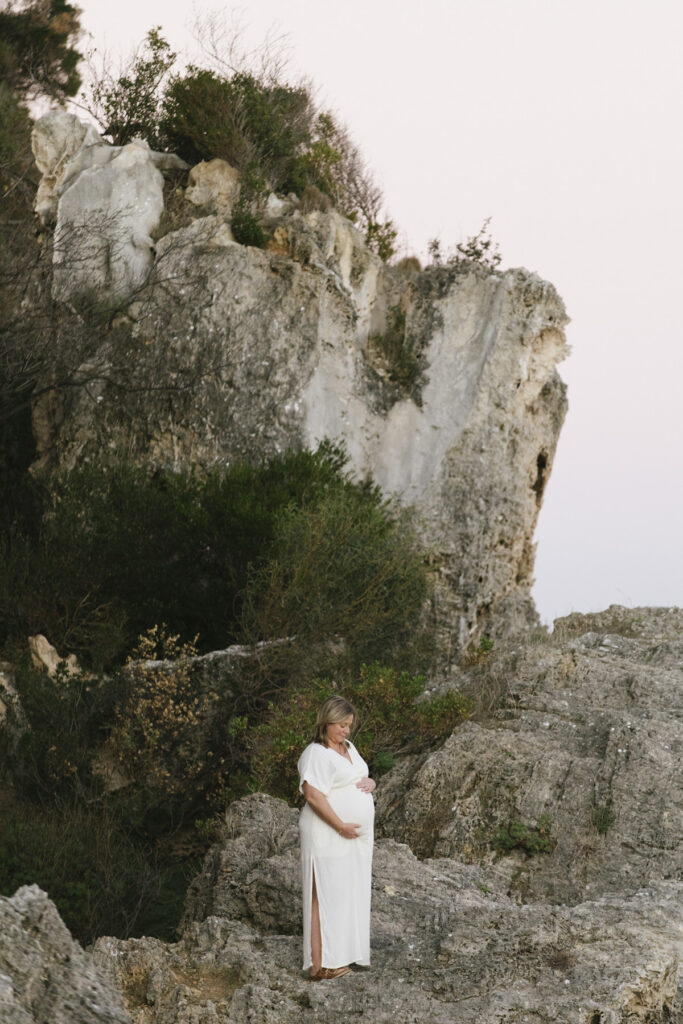 Expectant mother standing among the limestone cliffs during a golden hour maternity photography session at Bay View Park, Mosman Park, Perth.