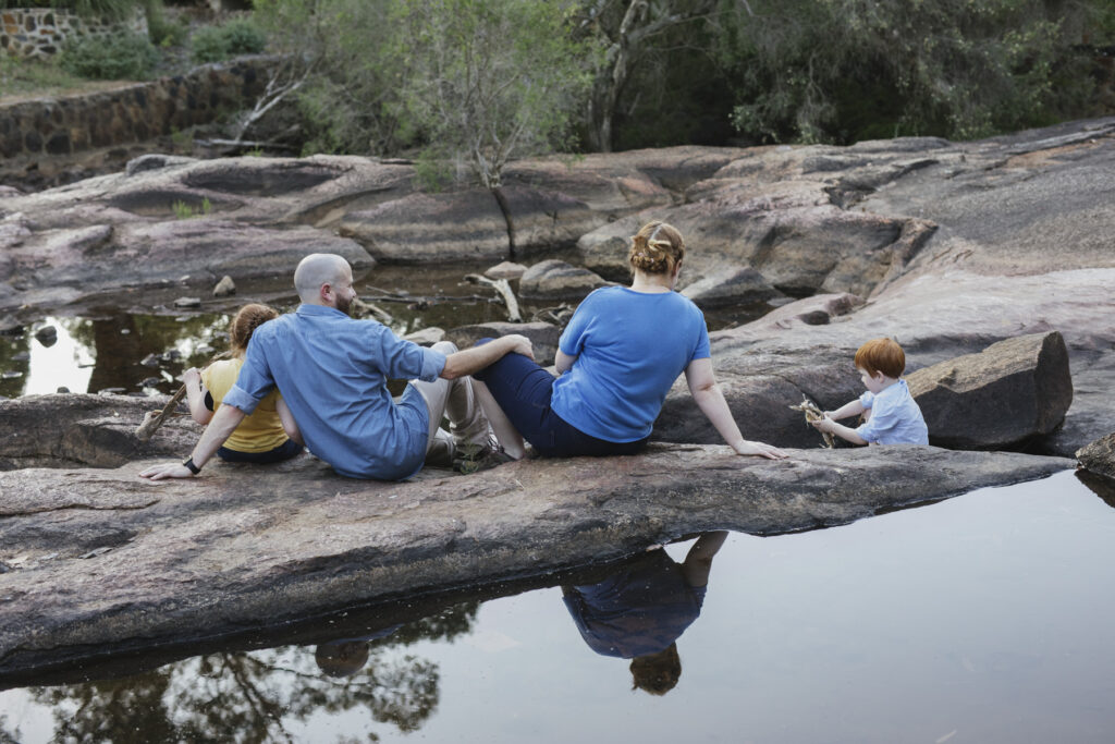 Family exploring the rocks and creek during a relaxed family photography session at Hovea Falls in Perth